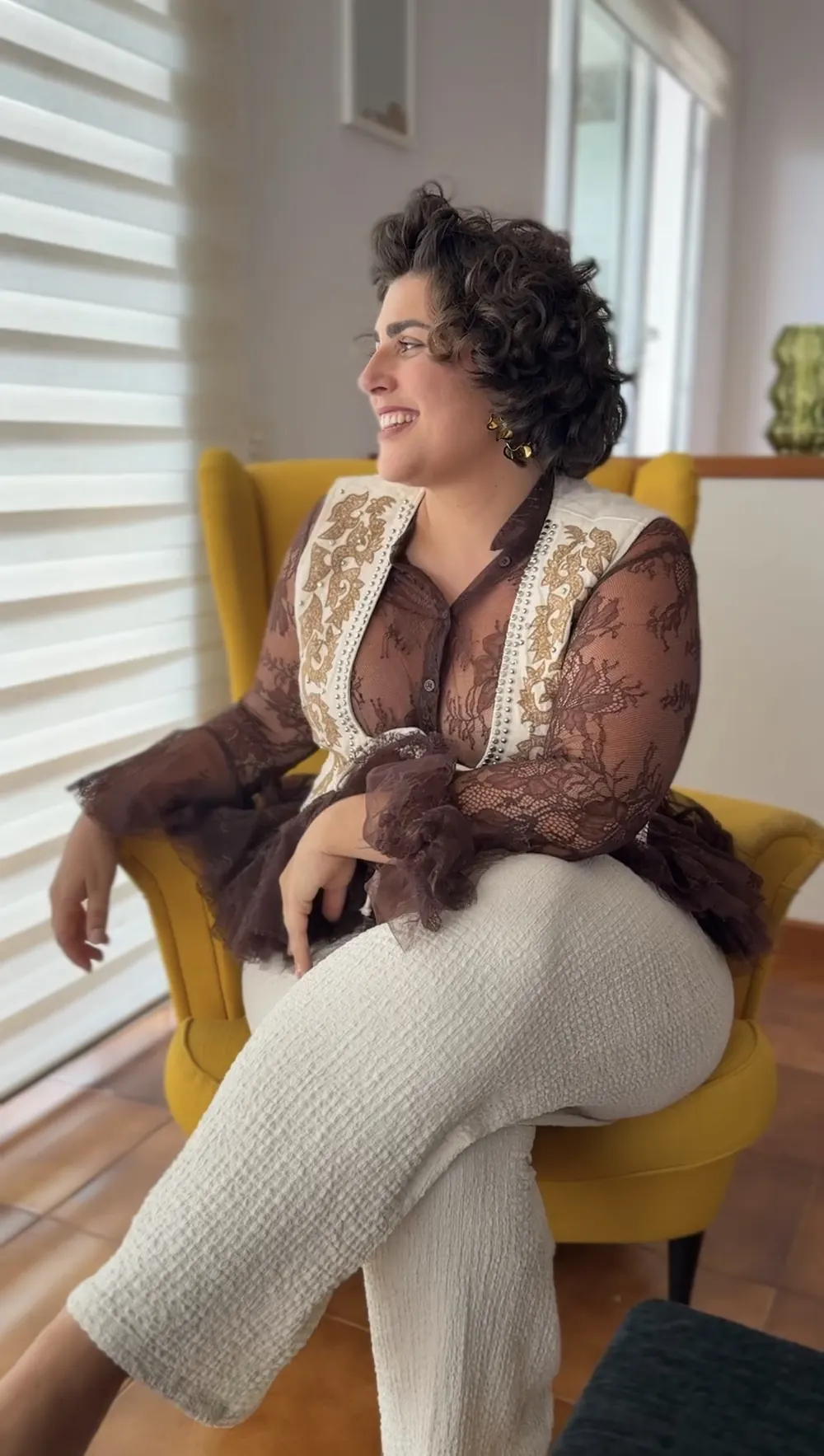 Lara Lapuente sentada en un sillón, sonriendo
